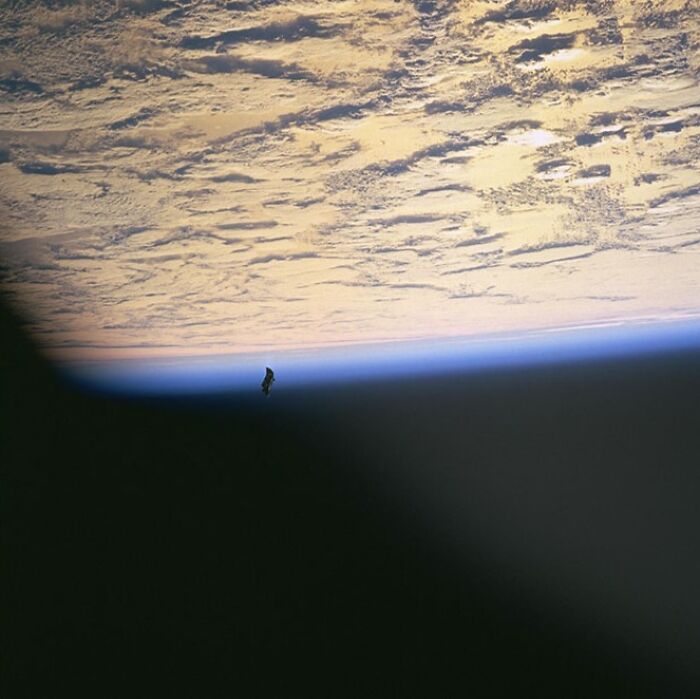 Dark shadow casts over Earth’s horizon from space, showing clouds and an object, a photo with mysteries behind it.