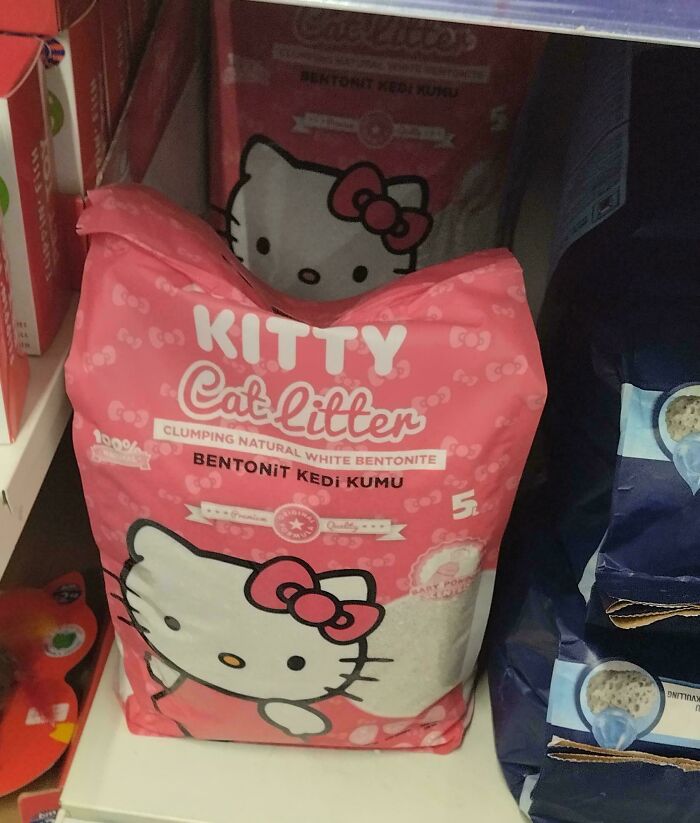 Pink kitty cat litter bag featuring a Hello Kitty design on a store shelf among other pet products.