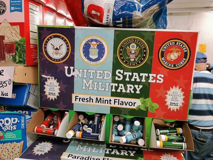 Display of United States military-themed lip balms with fresh mint flavor in a store, showcasing unique and nonsensical products.