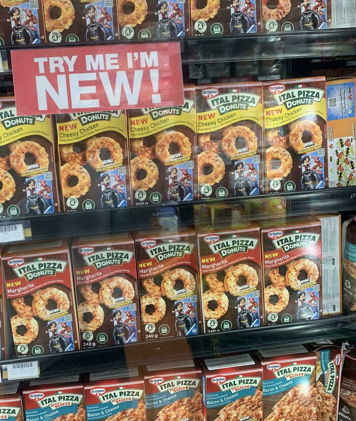 Boxes of Ital Pizza Donuts with cheesy chicken and margherita flavors displayed with a sign promoting new nonsensical food products.