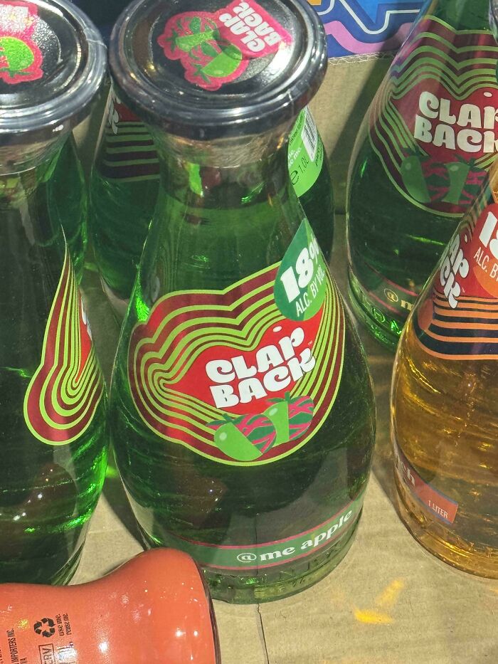Green glass bottles with unusual clam back labels featuring peppers and 18% alcohol, showcasing nonsensical products that actually exist.