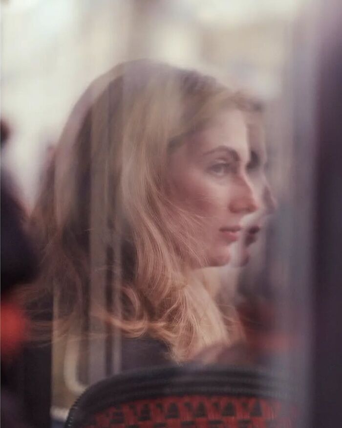 Blurred street photo of a blonde woman captured with artistic reflection by Greek photographer Marina Nota.