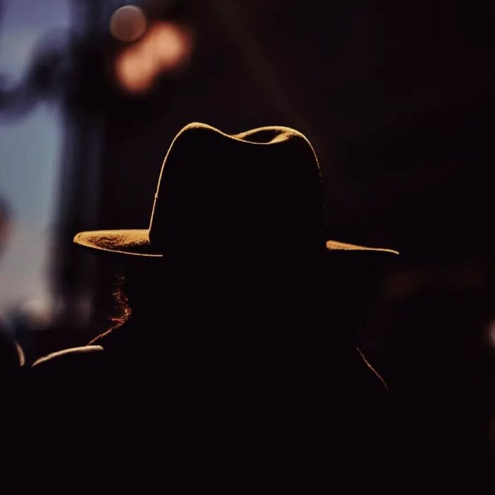 Silhouette of a person wearing a hat captured in a stunning street photo by Greek photographer Marina Nota.