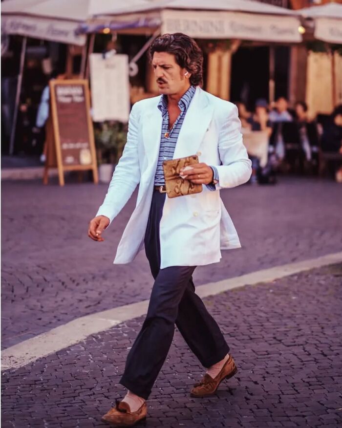 Stylish man walking on cobblestone street capturing the essence of street photos by Greek photographer Marina Nota.