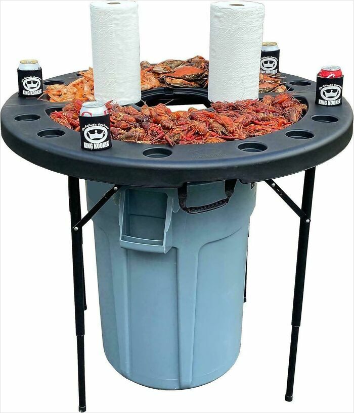Trash can with a raised table holding crawfish, drinks, and paper towels, showcasing one of the most nonsensical things that actually exist.