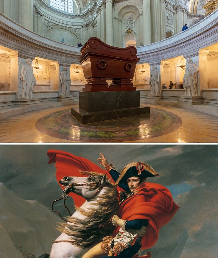 Tomb inside a grand rotunda surrounded by statues and a painting of a famous historical figure on horseback.