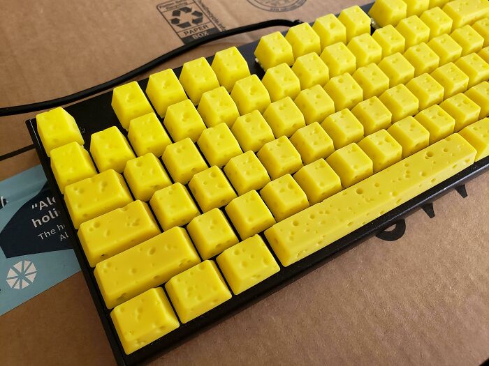 Yellow keyboard keys designed to look like blocks of Swiss cheese, creating a weird and unusual appearance.