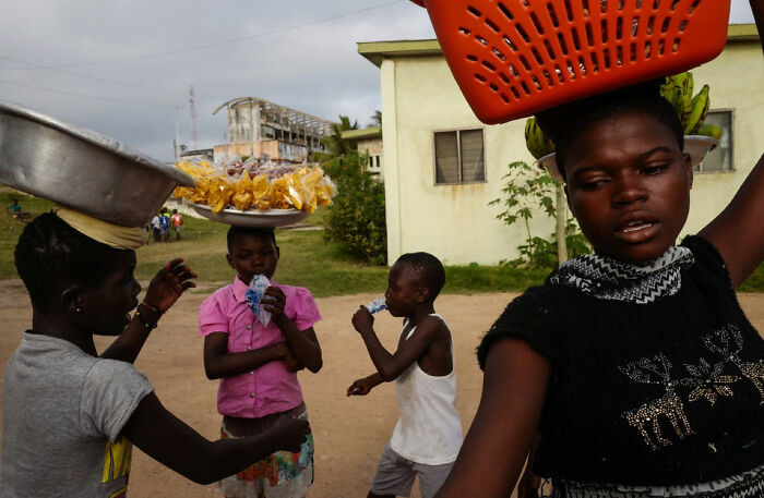 Children of the world carrying baskets and snacks, captured in a powerful photograph by Andrea Torrei outdoors.