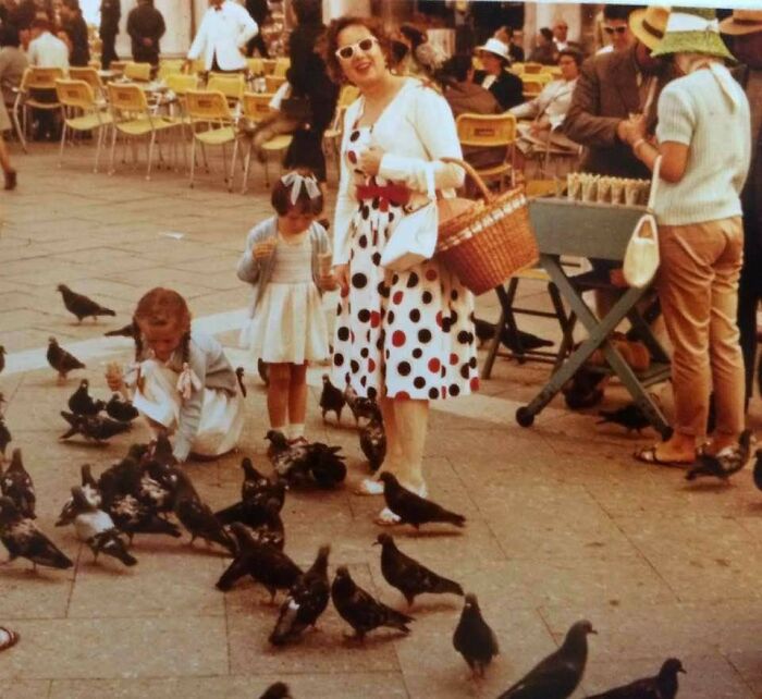 Vintage vacation scene with a woman and children feeding pigeons, capturing nostalgic moments before cell phone cameras existed