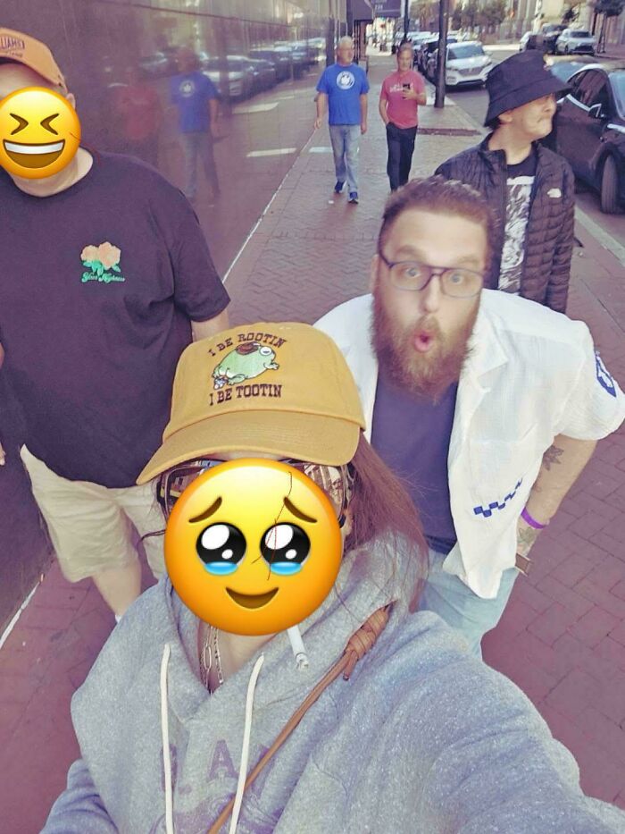 Group selfie on a city sidewalk with people laughing and reacting, capturing a funny celebrity kind of moment online.