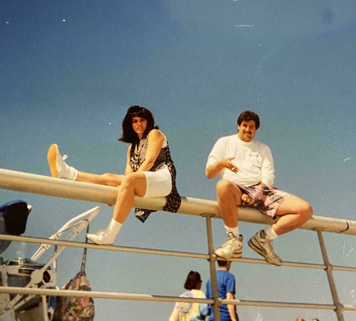 Two people sitting on a railing enjoying a sunny day, vintage vacation pics from a time before cell phone cameras.