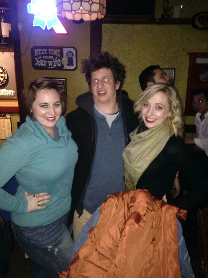 Three friends posing at a bar, with one man making a funny face in a celebrity fail moment from Johnny Derp online.