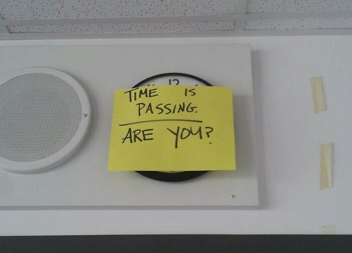 Yellow sticky note with funny message about time passing on a classroom clock, showcasing funny teacher humor.
