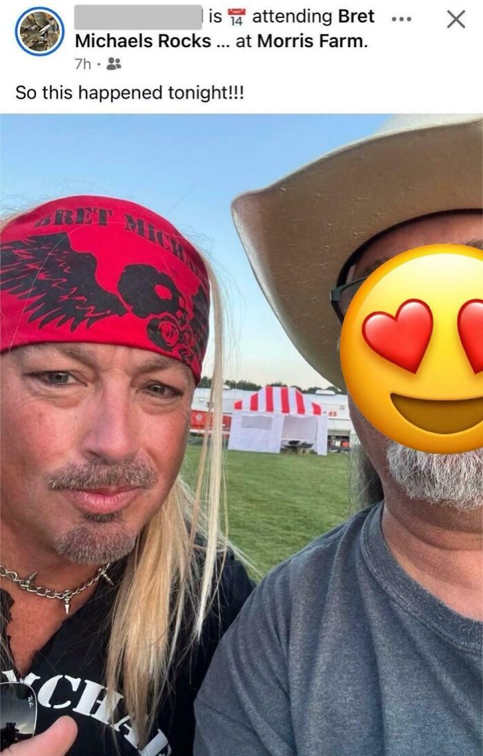 Man wearing a Bret Michaels bandana posing with a person whose face is covered by a heart eyes emoji in an outdoor setting.