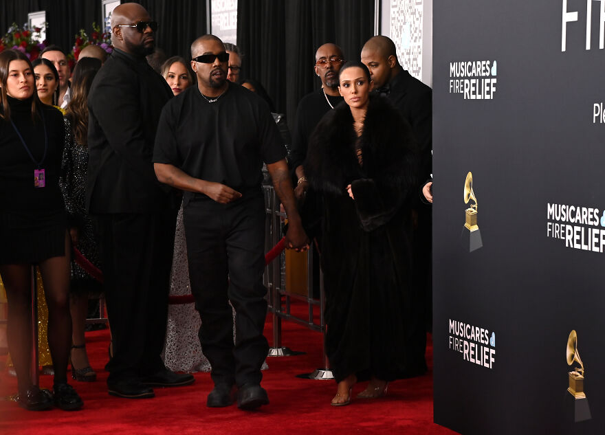 Kanye West and Bianca Censori walking the red carpet at a charity event, highlighting net worth and empire growth.