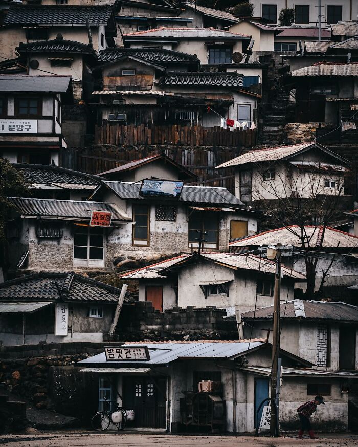 Dense cluster of old houses with tiled roofs in a quiet Asian village, capturing glimpses of everyday life in Asia.