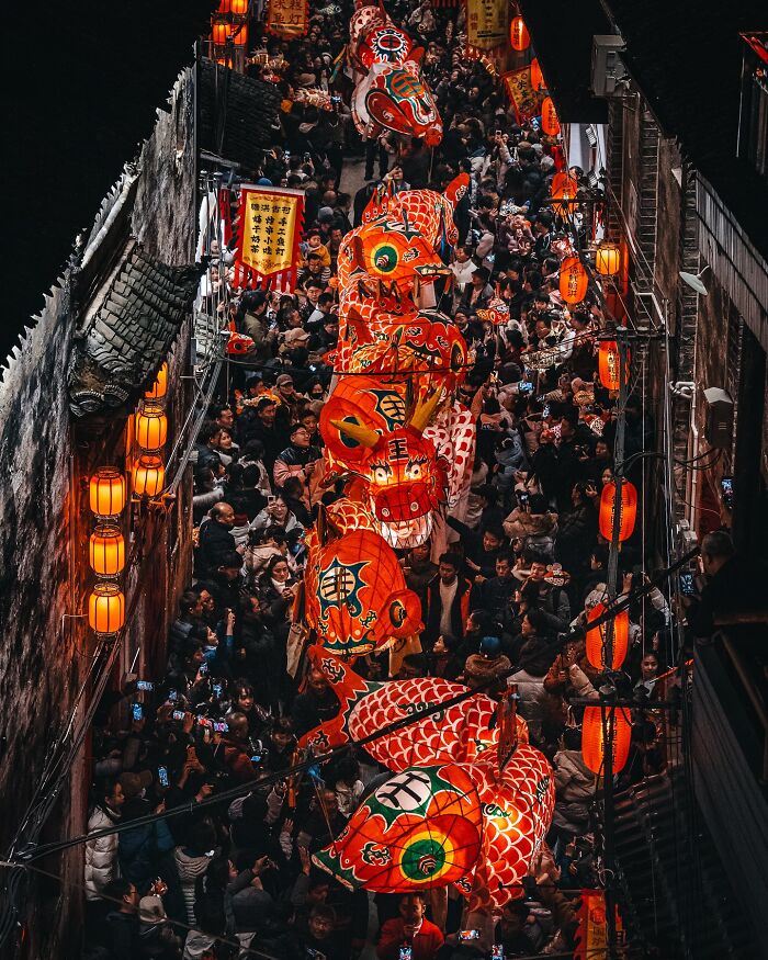 Crowded street festival in Asia featuring colorful dragon lanterns and traditional decorations, capturing everyday life moments.