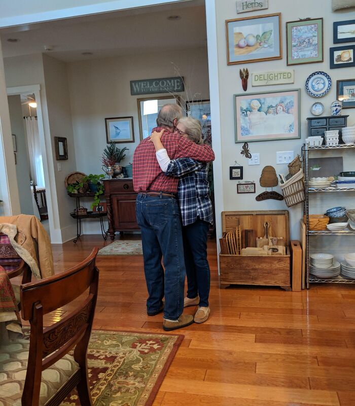 Elderly couple hugging warmly in a cozy home, capturing a funny and wholesome moment parents share with their kids.