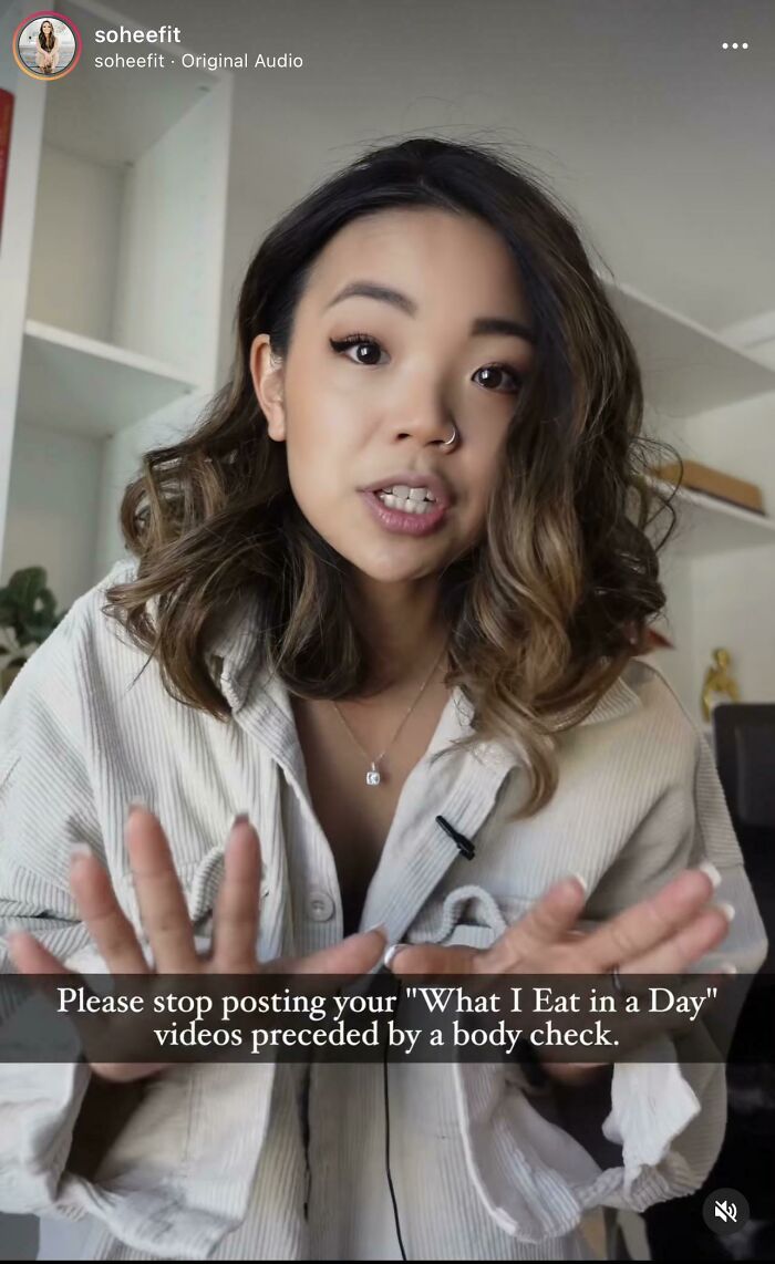 Young woman speaking on camera with a message about fitness influencers and baby gym safety in a casual indoor setting.