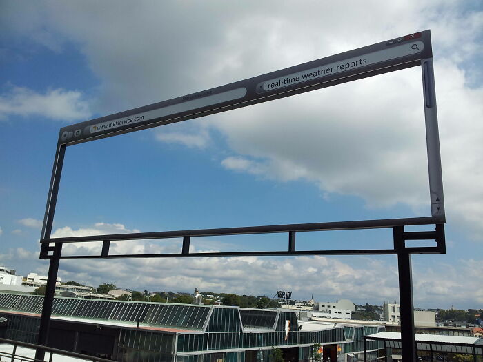 Funny and weird billboard designed like a web browser window showing the sky and cityscape behind it.