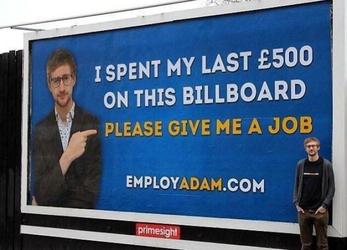 Man standing beside a funny and weird billboard reading I spent my last £500 on this billboard, please give me a job.