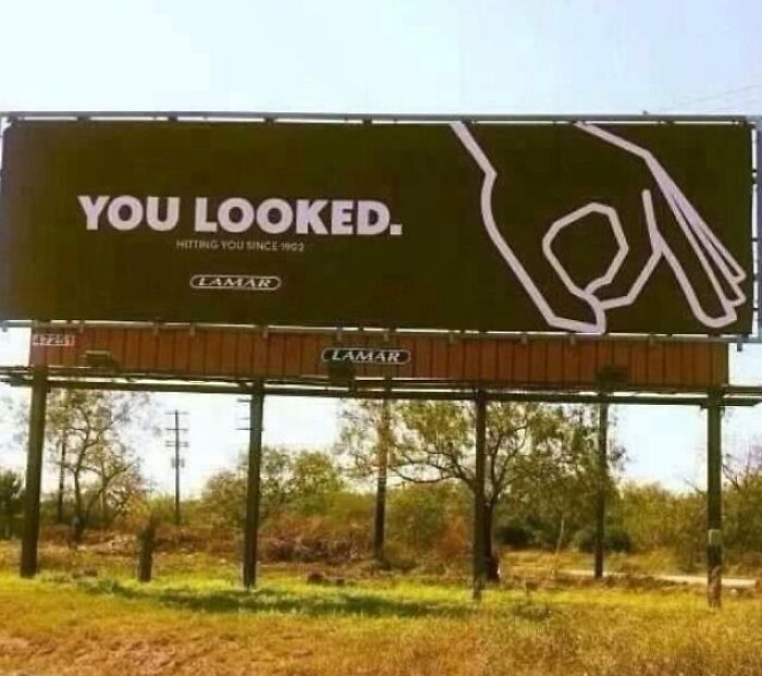 Funny and weird billboard with the phrase You Looked and a hand gesture, showcasing unusual advertising creativity outdoors.