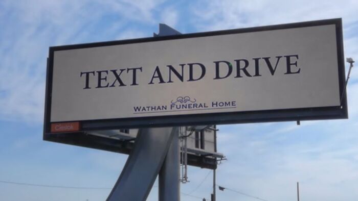 Billboard with a funny and weird message warning against texting and driving by a funeral home.