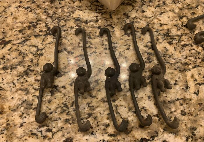 Set of five old, mysterious metal hooks shaped like monkeys, found and puzzled over by people online.