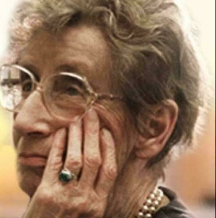 Elderly woman with glasses resting her face on hand, reflecting deeply, symbolizing inspiring facts over watching the news.