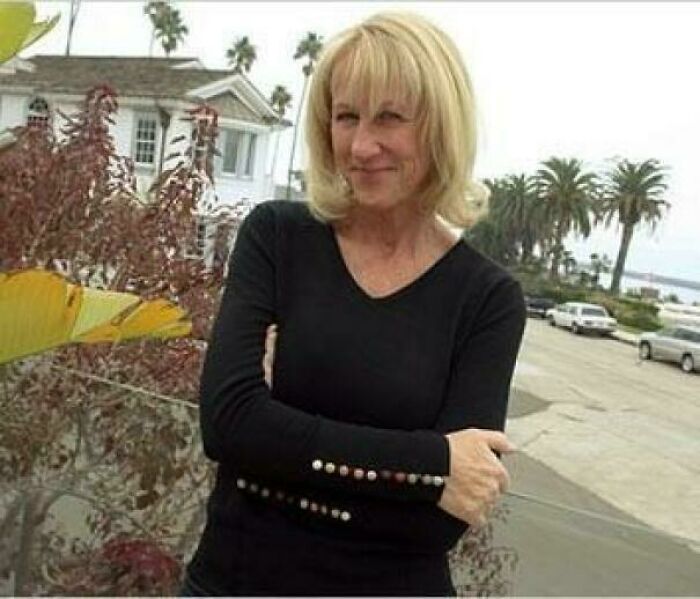 Woman in black long sleeve shirt standing outdoors near palm trees, representing inspiring facts better than news watching.