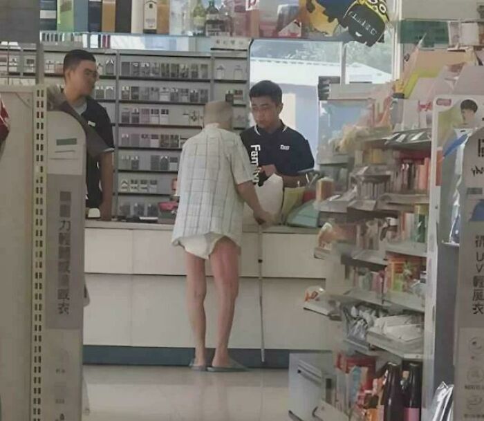 Elderly man using a cane shopping indoors with store clerks nearby in a moment captured among inspiring facts.