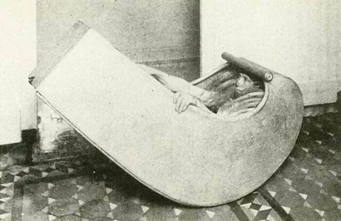 Person inside a vintage privacy device designed for reading or writing without distractions, inspiring facts concept.
