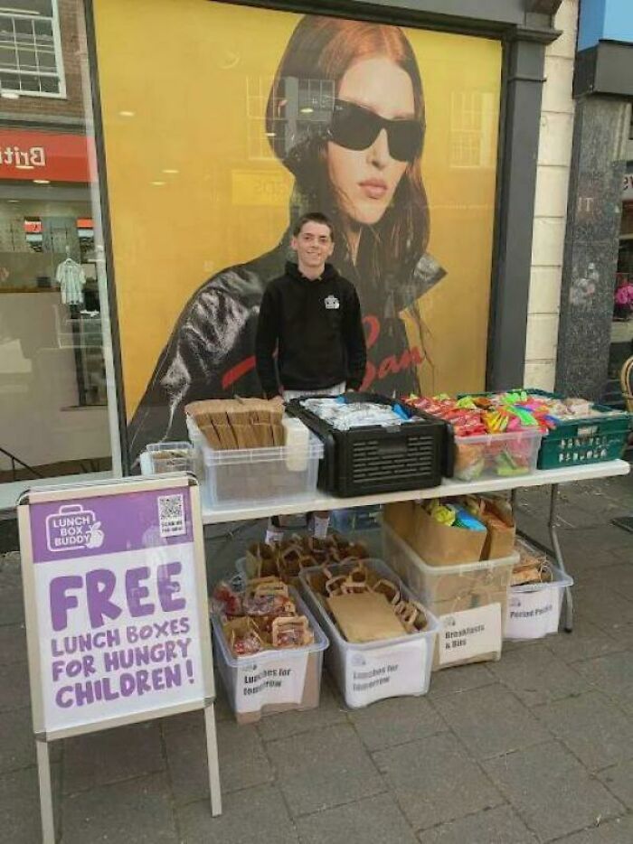 Young volunteer distributing free lunch boxes for children, spreading inspiring facts of kindness in the community.