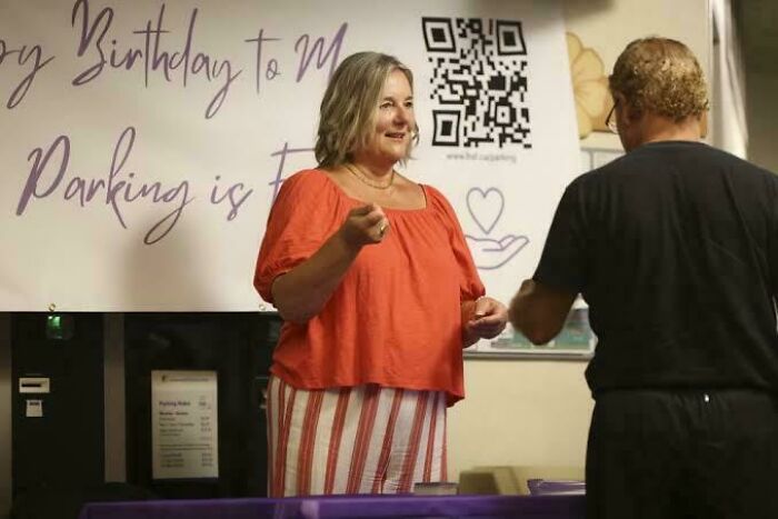 Woman in orange top sharing inspiring facts with man in casual setting during an engaging conversation event.