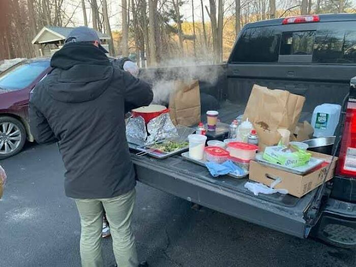 Person preparing food at the tailgate of a truck with various containers and bags, inspiring facts about daily life.