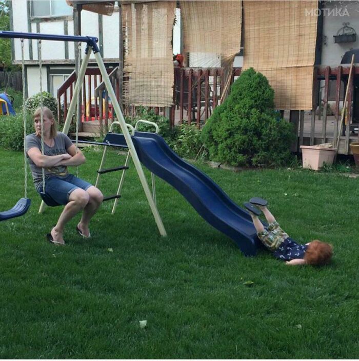 Child falling off a swing next to a slide in a backyard, capturing the moment the rope broke before disaster struck.