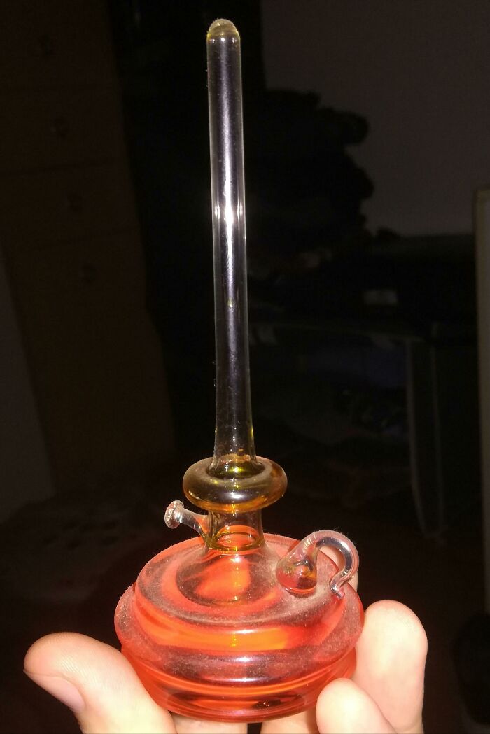 Hand holding an old, unknown vintage glass object with a tall narrow neck and curved features, found and shared online.