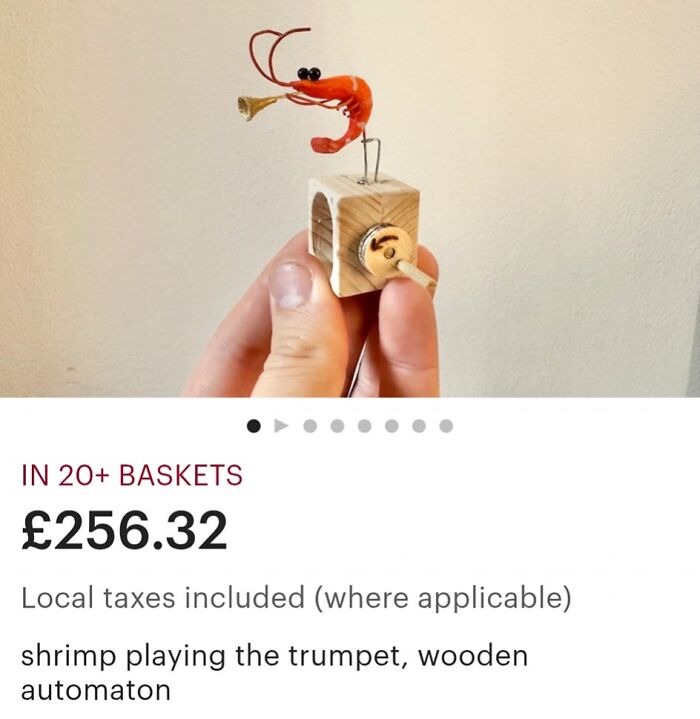 Hand holding a wooden automaton of a shrimp playing the trumpet, one of the weirdest purchases people would make quickly.