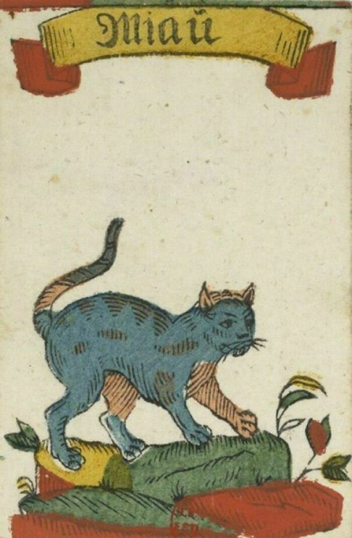 Medieval illustration of a blue and orange cat standing on colorful rocks with plants nearby, showcasing medieval cats artwork.
