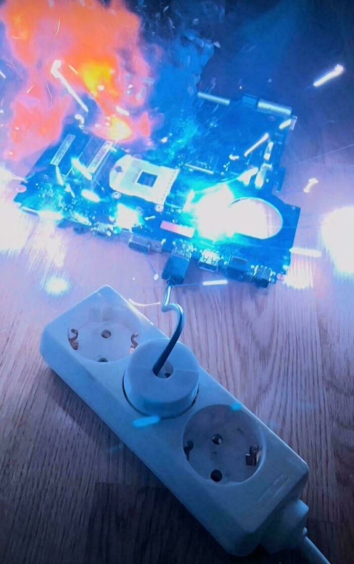 Circuit board sparks and catches fire while improperly connected to a power strip, illustrating handling electronics the wrong way.