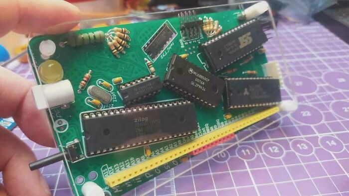 Close-up of a damaged electronic circuit board with misaligned and loose chips, highlighting improper soldering attempts.