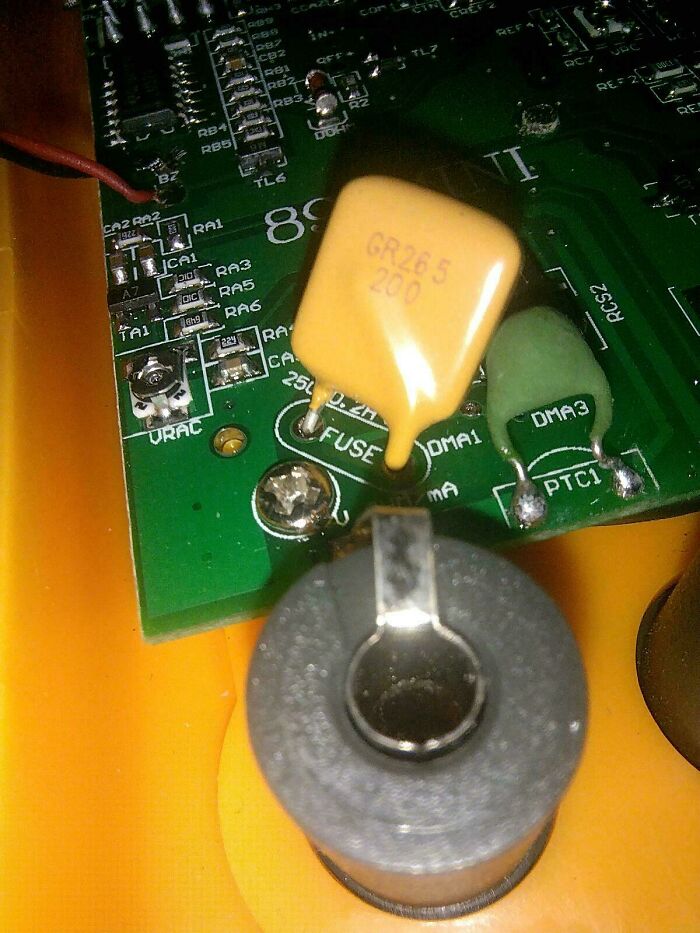 Close-up of an electronic circuit board with melted components, showing painful examples of handling electronics the wrong way.