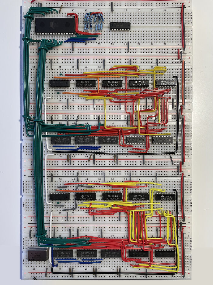 Complex electronics breadboard circuit with numerous colored wires and chips, illustrating soldering challenges and common mistakes.