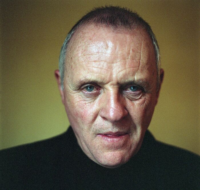 Close-up portrait of an older man with blue eyes wearing a black shirt, representing famous historical quotes SEO concept.