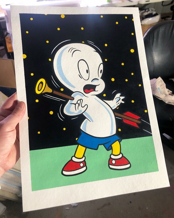 Hand holding pop culture cartoon character mash-up artwork with bright colors and playful design style.