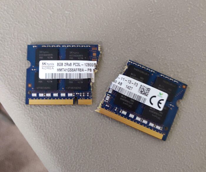 Two broken laptop RAM sticks placed on a table, illustrating damaged electronics handled the wrong way.