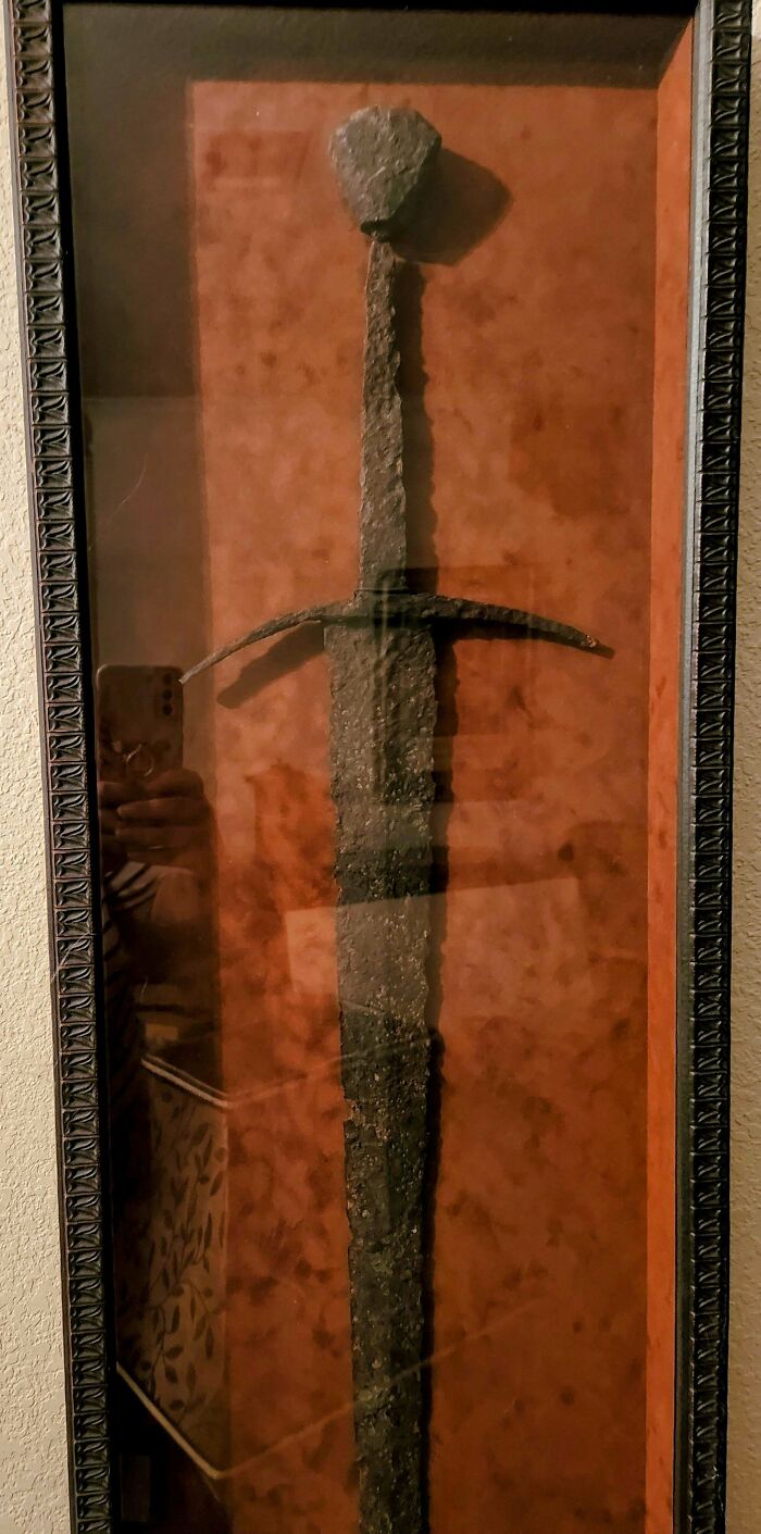 Rusty medieval sword displayed in a framed case, a prized artifact for medieval history enthusiasts and collectors.