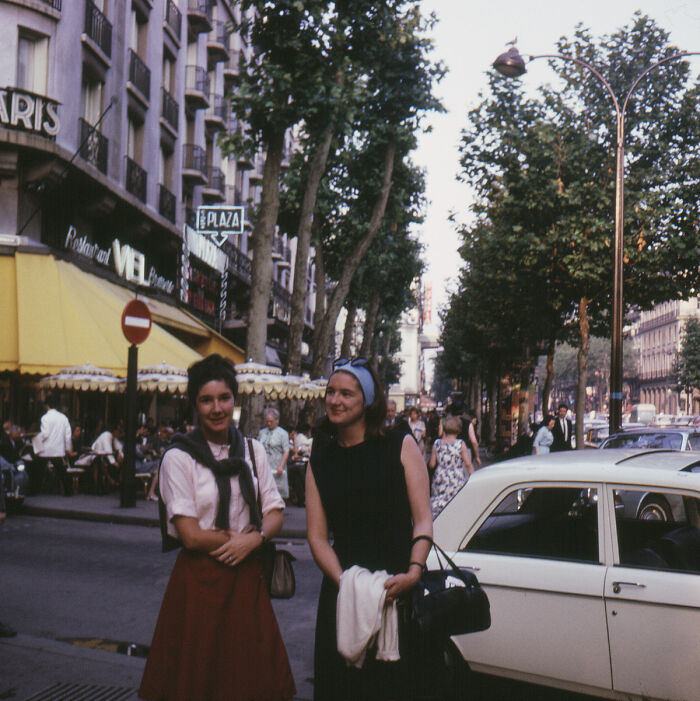 Two women posing on a city street during vacation, capturing a moment from a time before cell phones had cameras.