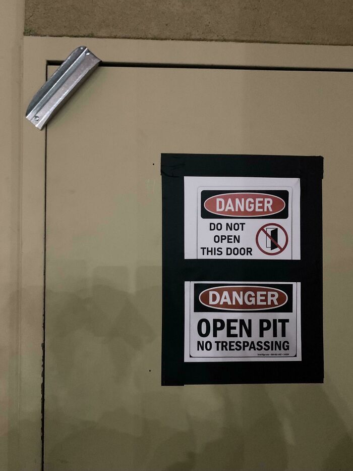 Warning signs on a door stating danger, no trespassing, and instructions not to open, showcasing unsettling job hazards.