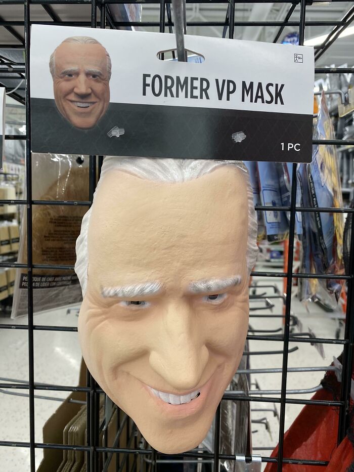 Off-brand Halloween costume mask labeled Former VP Mask with exaggerated facial features hanging on display.